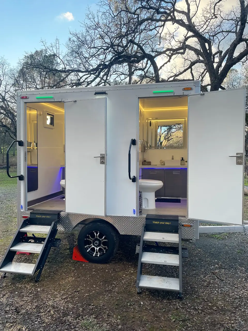 Two-stall restroom trailer lit at dusk